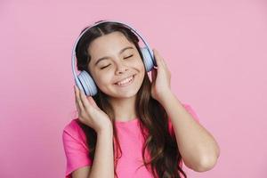positiv tonårsflicka i hörlurar lyssnar på musik foto