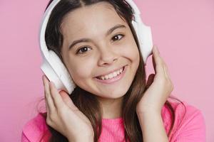 söt, vacker tonårsflicka som lyssnar på musik i hörlurar foto