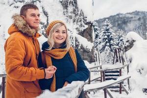 lyckligt kärleksfullt par som går i vinterparken och njuter av snö foto