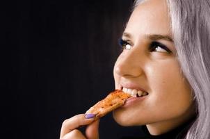 flicka som äter pizza. inte hälsosam mat. hemleverans. foto