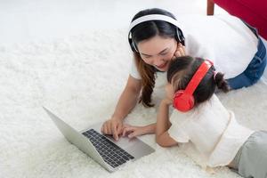 asiatisk mamma med att lära barn att studera från datorn hemma