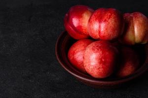 läckra söta persikor eller nektariner i en brun skål foto