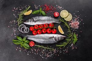 färsk fisk havsabborre och ingredienser för matlagning. rå fisk havsbass foto