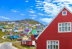 typisk arkitektur av Grönland stad qarqotoq med färgad hus belägen nära fjordar och isberg foto
