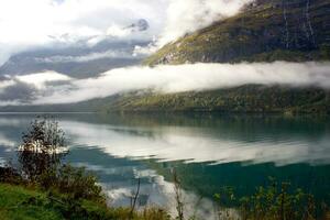 norska landskap i höst nära loen och stryk i norge, moln reflexion på de sjö med turkos vatten foto