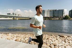 en löpare gör övning varje dag, en friska livsstil. en man Träning kondition i en bekväm t-shirt. en sportig man joggning i sneakers. foto