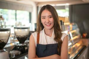ett asiatisk kvinna entreprenör eller Barista arbetssätt i modern kaffe affär , begrepp små företag foto