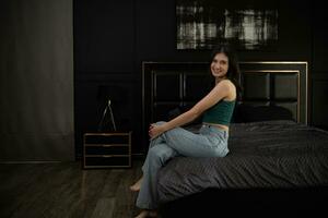ung kvinna Sammanträde på de säng i de rum på natt tid. foto