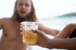 multietnisk grupp av vänner har roligt på de strand, dricka öl och har roligt foto
