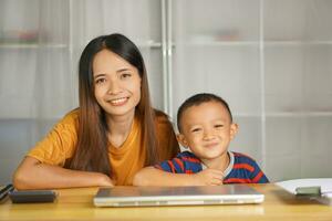 Lycklig mor och son på Hem skrivbord foto