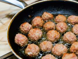 köttbullar med olja i fräsning panorera. foto