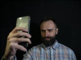 snygg man med skägg och mustasch gör selfie i telefonen foto