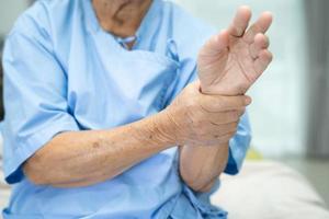asiatisk senior kvinna patient känner smärta hennes handled och hand foto