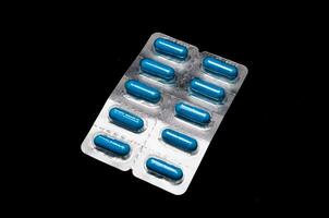 blå piller isolerat på svart bakgrund foto