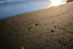 de Sol är lysande på de sand på de strand foto
