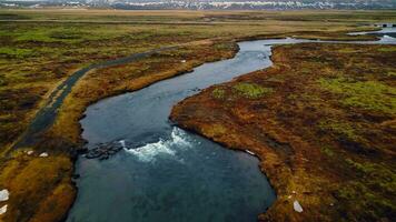 skön oxarafoss vattenfall panorama, Drönare skott av isländsk kaskad löpning ner av klippa. enorm vatten ström strömmande och faller av massiv klippig kullar i island. långsam rörelse. foto