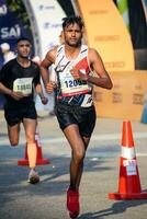 ny delhi, Indien - juli 16 2023 - vedanta delhi halv maraton lopp efter covid i som maraton deltagarna handla om till korsa de Avsluta linje, delhi halv maraton 2022 foto