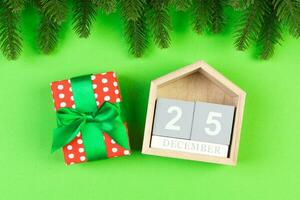 topp se av gran träd, trä- kalender och gåva låda på färgrik bakgrund. de tjugo femte av december. glad jul tid med tömma Plats för din design foto