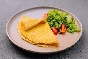 pannkaka med grön sallad på tallrik foto