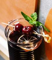 glas av alkohol tinktur tillverkad från körsbär frukt foto