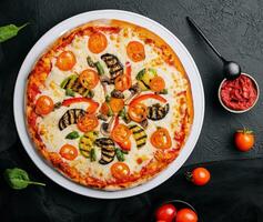 vegetarian pizza med zucchini, äggplanta, svamp och tomat foto