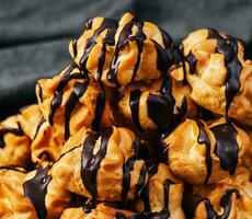 profiteroles med choklad grädde stänga upp foto