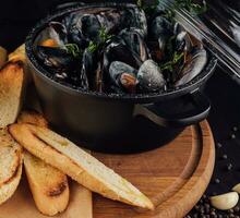 traditionell utegrill italiensk blå mussla i vin sås med baguette bröd foto