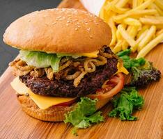 burger med lök pommes frites och frites foto