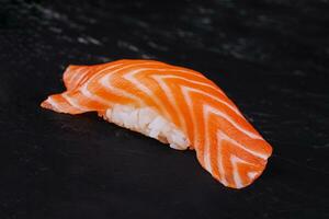 lax nigiri sushi på svart sten foto