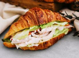 croissant smörgås med skinka, tomat och sallad foto