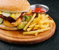 saftig burger med lök ringar och franska frites foto