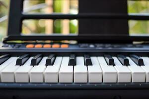 närbild av piano nycklar. piano svart och vit nycklar och piano tangentbord musikalisk instrument placerad på de Hem balkong under solig dag. foto