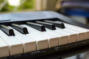 närbild av piano nycklar. piano svart och vit nycklar och piano tangentbord musikalisk instrument placerad på de Hem balkong under solig dag. foto