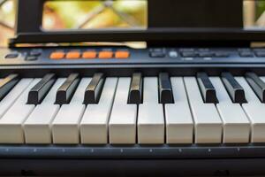 närbild av piano nycklar. piano svart och vit nycklar och piano tangentbord musikalisk instrument placerad på de Hem balkong under solig dag. foto