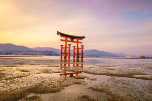 den flytande porten till itsukushima-helgedomen vid solnedgången foto