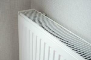 vit radiator på grå vit vägg. lägenhet uppvärmning installation systemet, foto