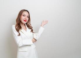 porträtt vacker asiatisk affärskvinna med handen presenterar eller pekar på vit bakgrund