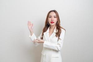 porträtt vacker asiatisk affärskvinna med handen presenterar eller pekar på vit bakgrund