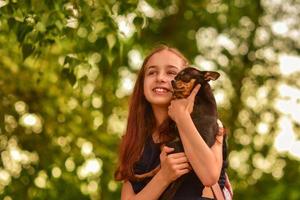 tjejbarn skolflicka håller och leker med hund. vänner. foto