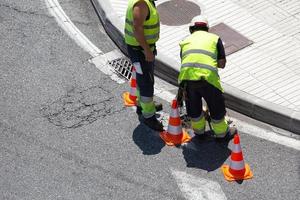 arbetare som reparerar en asfaltväg på staden foto