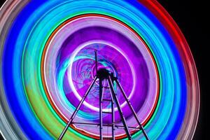 fläck rörelse av ljus ferris hjul. lång exponering ljus på natt roligt parkera, glad gå runt om. foto