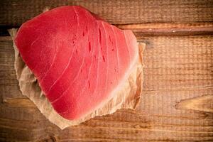 rå tonfisk biff med papper på de tabell. foto
