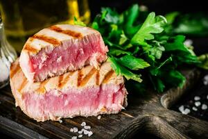 en bit av grillad tonfisk med persilja. foto