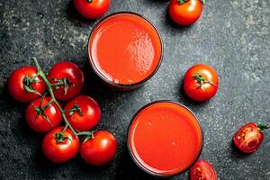 färsk tomat juice. på en svart bakgrund. foto