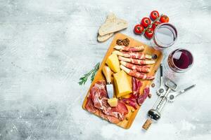 antipasto bakgrund. olika kött och ost snacks med röd vin. foto