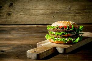 ett burger med nötkött, sallad och grönsaker. foto