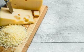 färsk riven ost på en trä- styrelse. foto