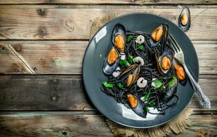 medelhavs mat. spaghetti med bläckfisk svart bläck och musslor. foto