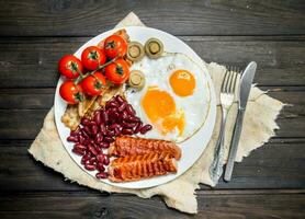 traditionell engelsk frukost med friterad ägg, korvar och bönor. foto