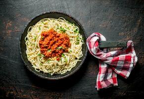 spaghetti med bolognese sås i panorera med servett. foto